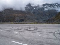 an image of a person skating on a runway in the snow and mountains below it