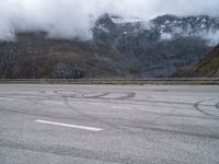 an image of a person skating on a runway in the snow and mountains below it