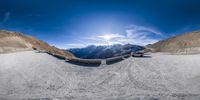 a fish eye lens view of a ski area with snow capped mountains and ski tracks