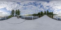 fisheye lens photograph of ski area with lake and trees in the background as seen on a tripod