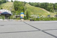 a person is riding on a skate board at a ski park with a blue umbrella