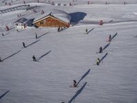 a ski resort has skiers and snowboarders following them through the white snow