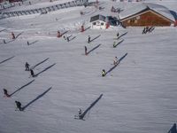 a ski resort has skiers and snowboarders following them through the white snow