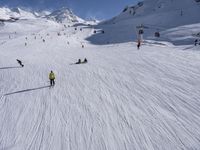 a ski slope full of people with skiers up to the top of it and hills in the background