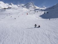 a ski slope full of people with skiers up to the top of it and hills in the background