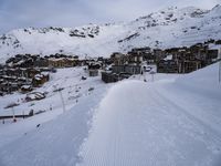 snow covered slope in the middle of a ski area as people ski on it near ski lift