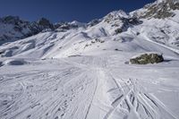 the ski slope has many tracks in it and skis along the side of it