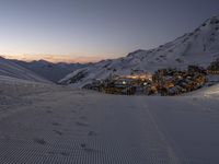 skiers walk on the slopes toward an image of a resort village in the mountains