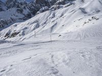 a skier on a snowy mountain side with snow surrounding him and several wires in the foreground