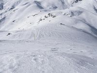 a skier on a snowy mountain side with snow surrounding him and several wires in the foreground