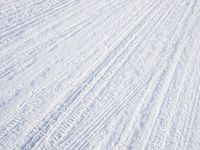 a person riding skis down a snow covered slope covered in snowboarding and holding two poles