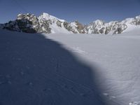 a skier skiing through the snow by some mountains and boulders and clouds in the sky