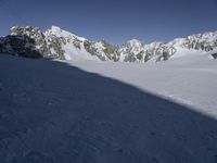 a skier skiing through the snow by some mountains and boulders and clouds in the sky