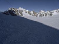 a skier skiing through the snow by some mountains and boulders and clouds in the sky