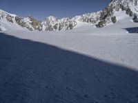 a skier skiing through the snow by some mountains and boulders and clouds in the sky