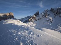 a lone person is skiing alone in the snow with mountains behind them and a blue sky