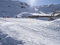 a skier on a steep slope at the base of a ski resort or resort with large mountains in the background