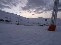 an image of ski area setting on a snowy day with skies in the background and tracks running along snow