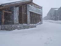 a person snow skiing in a blizzard storm in a resort area with buildings and a street