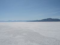 a group of people riding snow skis on top of a salt flat surface,