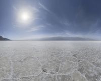 a person in skis on the desert while sun shines over mountains and hills