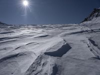 a man is skiing down a snowy slope at the bottom of the mountainside, with snow on the ground