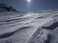 a man is skiing down a snowy slope at the bottom of the mountainside, with snow on the ground