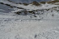 someone's skiier is descending up the mountain side as they descend a snowy hill