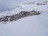 snow covered slope in the middle of a ski area as people ski on it near ski lift