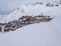 snow covered slope in the middle of a ski area as people ski on it near ski lift