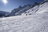 a skier is going downhill in the snow by a ski lodge on a mountain top