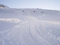 a person in skis rides their skis on the snow covered mountainside, above a hill