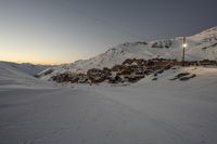 a person on skis is standing in a snowy area at sunrise by the mountains