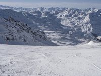 a skier on a mountain slope with a view of a valley and mountains in the background