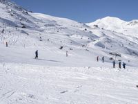 the people are all skiing in the mountains, and one person is standing near the snow