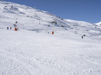 the people are all skiing in the mountains, and one person is standing near the snow