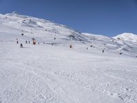 the people are all skiing in the mountains, and one person is standing near the snow