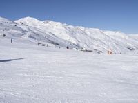 the people are all skiing in the mountains, and one person is standing near the snow