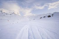 skis are lined up along the snowy slopes on a mountaintop with a ski lift in the background