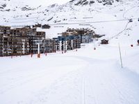 snow covered slope in the middle of a ski area as people ski on it near ski lift