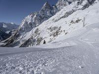 someone skiing down the snow covered slopes near large mountains in the background are the mountains