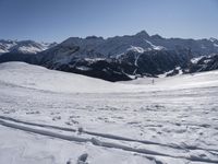 a person in yellow jacket on skis and poles standing near a snow covered hill