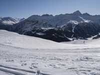 a person in yellow jacket on skis and poles standing near a snow covered hill