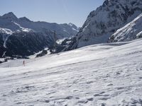 a person in yellow jacket on skis and poles standing near a snow covered hill