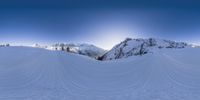 a skier moves along the slopes through deep snow as he rides down a mountain slope