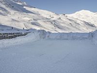 man in yellow jacket skiing down a mountain on snow covered slope outside of building area