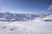 people skiing on top of a slope in front of ski lift over the mountains and snow covered ground