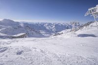 people skiing on top of a slope in front of ski lift over the mountains and snow covered ground