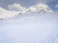 the skis are at the base of the slope line as they travel through the snow