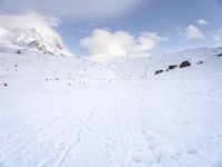 the skis are at the base of the slope line as they travel through the snow